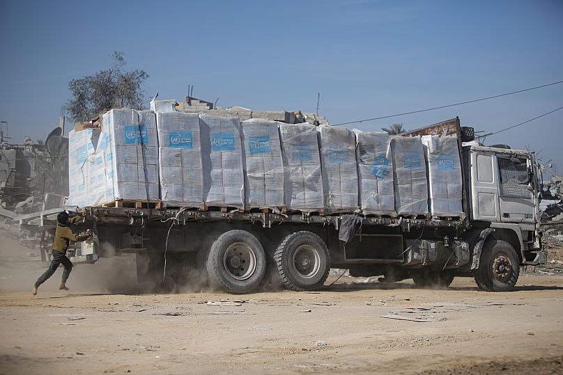 Un enfant palestinien poursuit un camion d'aide humanitaire arrivé par le point de passage de Kerem Shalom entre l'Égypte et la bande de Gaza, à Rafah, mardi 21 janvier 2025.