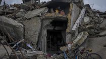 Mohammad Naser sits by a fire as he takes cover from the rain under the destruction of his house caused by the Israeli air and ground offensive in Jabaliya, Gaza Strip.