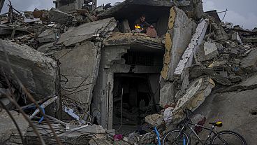 Mohammad Naser sits by a fire as he takes cover from the rain under the destruction of his house caused by the Israeli air and ground offensive in Jabaliya, Gaza Strip.