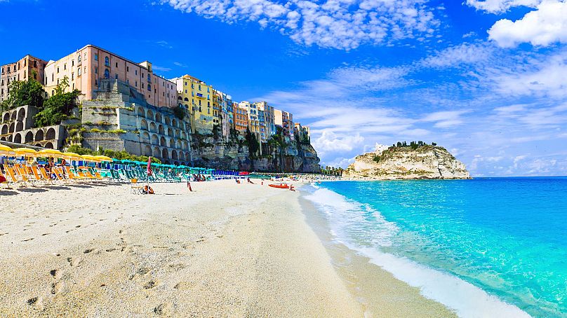 Una playa tranquila con tumbonas y sombrillas en Tropea