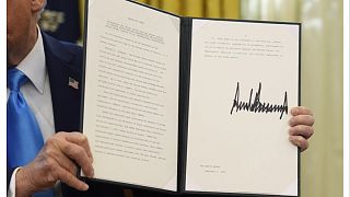 El presidente Trump sostiene una orden ejecutiva.
