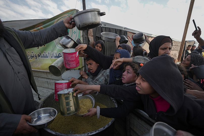 فلسطينيون يكافحون للحصول على الطعام في مركز توزيع في خان يونس بقطاع غزة في 9 يناير/كانون الثاني 2025