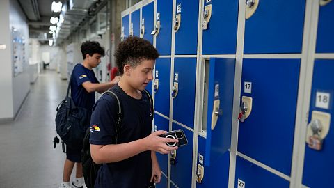 Students store their mobile phones in lockers as they head to class under a new law restricting their use on campus at Porto Seguro School in Sao Paulo, Thursday, Feb. 6, 2025