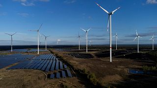 Wind turbines spin at the Klettwitz Nord solar energy park near Klettwitz, Germany.