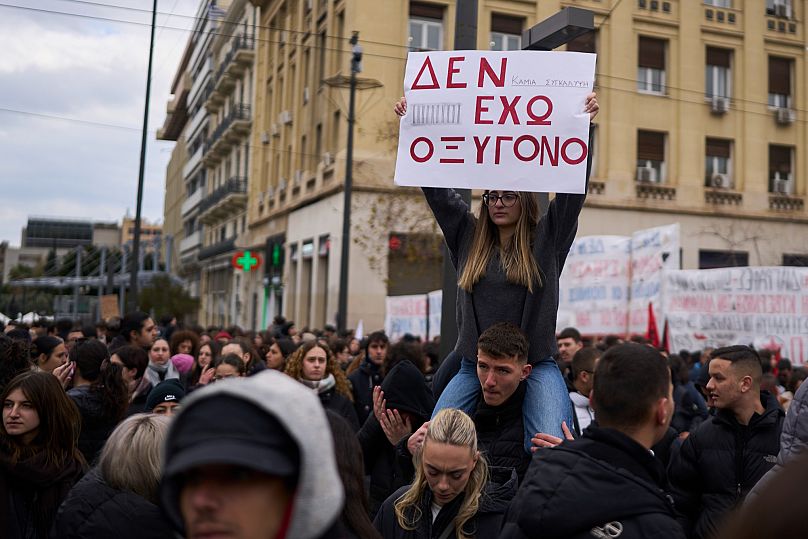 Una studentessa con il cartello "Non ho ossigeno" durante le proteste ad Atene