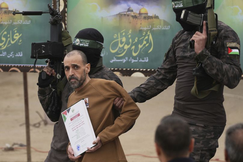 Israeli captive Eli Sharabi, who has been held hostage by Hamas in Gaza since October 7, 2023, is escorted by Hamas fighters in Deir al-Balah, Gaza, February 8 2025