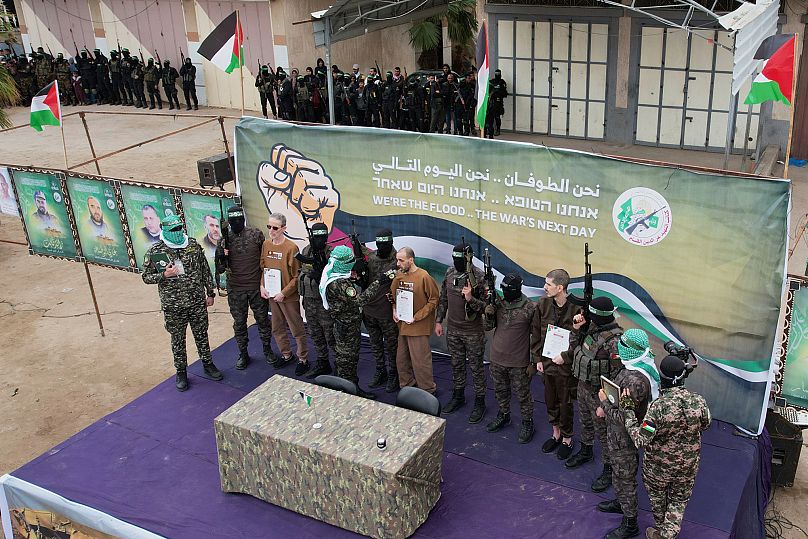 الأسرى الإسرائيليون، أوهاد بن عامي وإيلي شرابي وأور ليفي يرافقهم مقاتلو حماس قبل تسليمهم إلى الصليب الأحمر في دير البلح، وسط قطاع غزة، السبت 8 فبراير 2025.