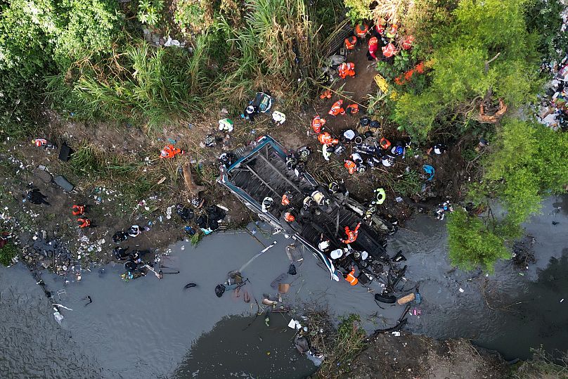 Les pompiers travaillent sur les lieux de l'accident mortel d'un bus tombé d'un pont dans les environs de la ville de Guatemala, le lundi 10 février 2025.