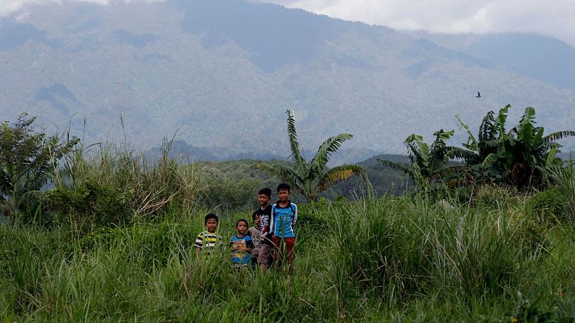 Children stand on a field at the planned development site near Gunung Gede Pangrango National Park in Bogor, West Java, 8 March 2017.