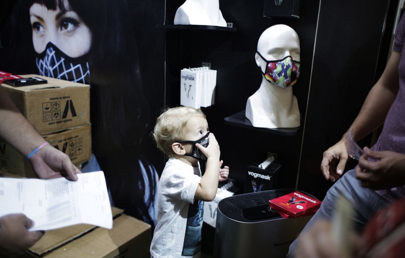 A child puts on a face mask inside a shop selling masks to fight air pollution in New Delhi, India.