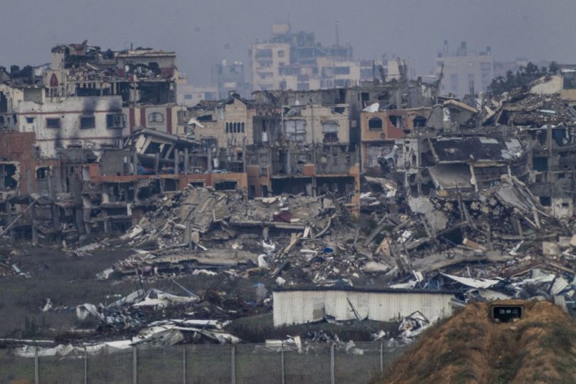 Zniszczone budynki wskutek bombardowań izraelskich w północnej części Strefy Gazy, widziane z południowego Izraela.