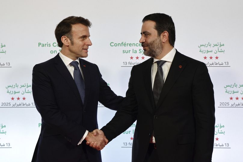 France's President Emmanuel Macron, left, greets Syria's Interim Foreign Minister Asaad Al-Shibani during the International Conference on Syria