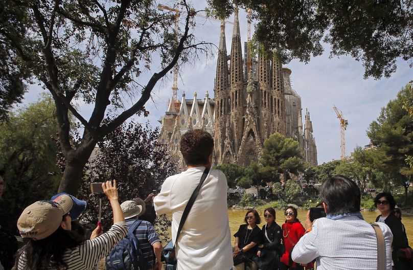 Archivo: Los turistas posan frente a la Sagrada Familia de Gaudí en Barcelona el 26 de mayo de 2016.