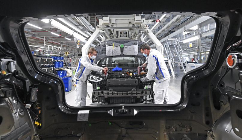 Employees of German car producer Volkswagen Sachsen, work with on the assembly of the ID.3 in the vehicle plant in Zwickau, Germany.