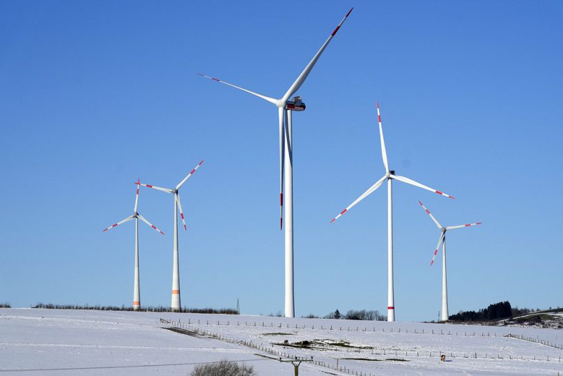 Wind turbines are pictured under a blue sky on a cold winter day in Brilon, Germany.