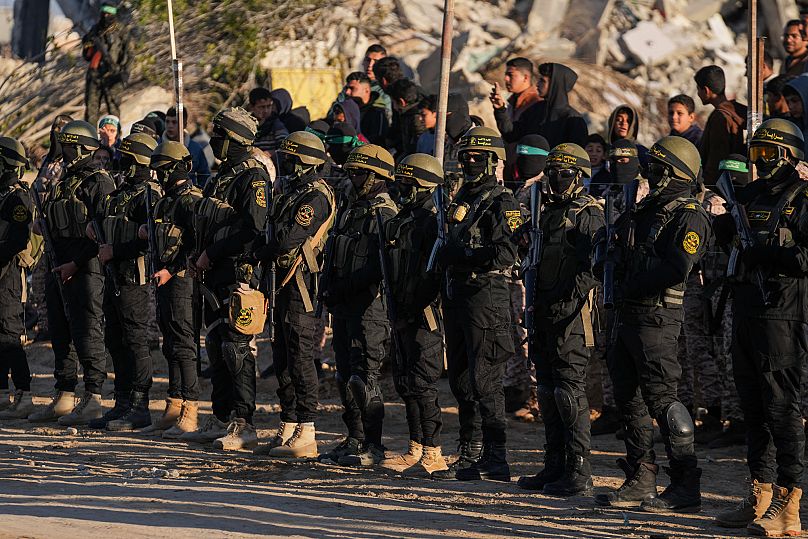 مقاتلون من حركة الجهاد يتخذون موقعاً قبل إطلاق سراح الرهائن في خان يونس، قطاع غزة، السبت 15 فبراير/شباط 2025