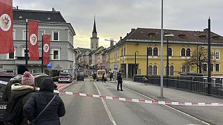 People look into a cordoned off area where a 23-year-old man stabbed several people in the southern Austria city of Villach, Saturday, Feb. 15, 2025
