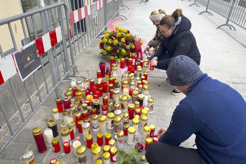 People light candles at the site of stabbing a day after an attack that left a 14-year-old dead and five others injured, in Villach, Austria, Sunday, Feb. 16, 2025. 