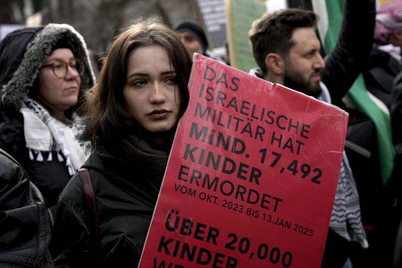 Γυναίκα κρατάει πλακατ που γράφει: «Ο ισραηλινός στρατός έχει δολοφονήσει τουλάχιστον 17.492 παιδιά», κατά τη διάρκεια διαμαρτυρίας κατά της Διάσκεψης του Μοναχου