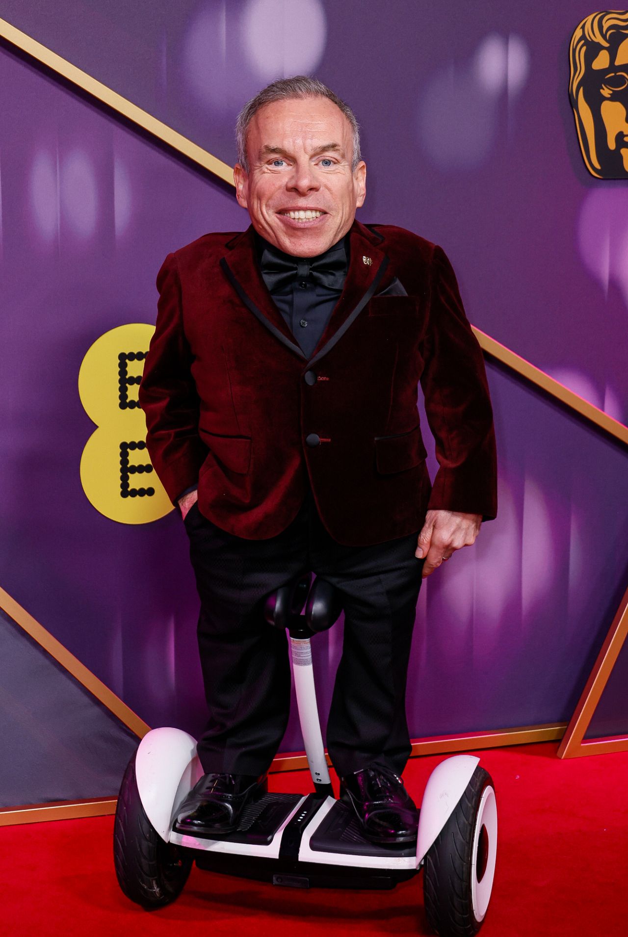 Warwick Davis poses for photographers upon arrival at the 78th British Academy Film Awards, BAFTA's