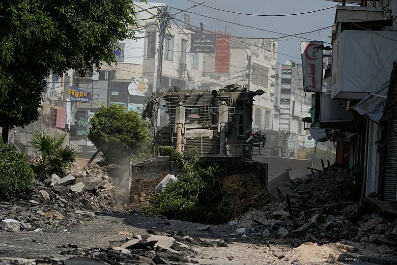 جرافة عسكرية إسرائيلية تمزق طريقًا مليئًا بالركام خلال غارة للجيش في جنين، الضفة الغربية، الاثنين، 2 سبتمبر/أيلول 2024