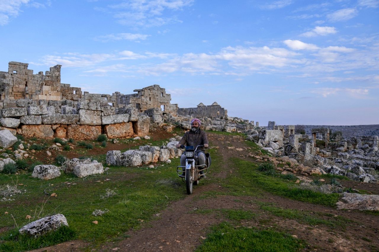 A man rides a motorbike past the remains of the Dead Cities archaeological site on the outskirts of Idlib, Syria.