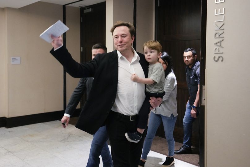  إيلون ماسك وهو يحمل طفله، بعد حديثه في مؤتمر التسويق POSSIBLE، يوم الثلاثاء 18 أبريل 2023، في ميامي بيتش، فلوريدا. 