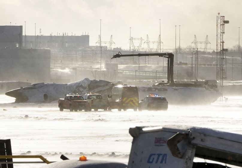 Rettungsfahrzeuge sind in der Nähe eines auf dem Kopf stehenden Flugzeugs der Delta Air Lines, Montag, 17. Februar 2025. 