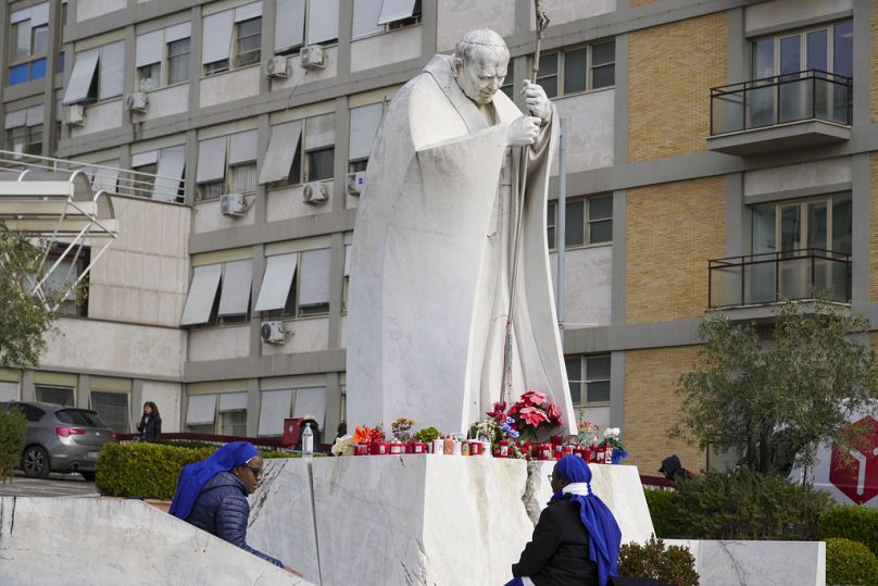 Suore pregano accanto alla statua di Papa Giovanni Paolo II davanti al Policlinico Agostino Gemelli, Roma, 17 febbraio 2025