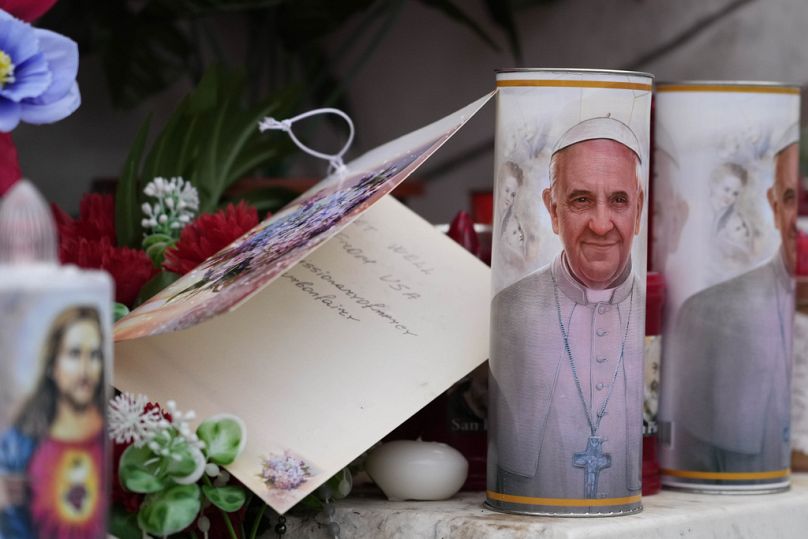 Velas con la cara del Papa Francisco en los alrededores del hospital romano.