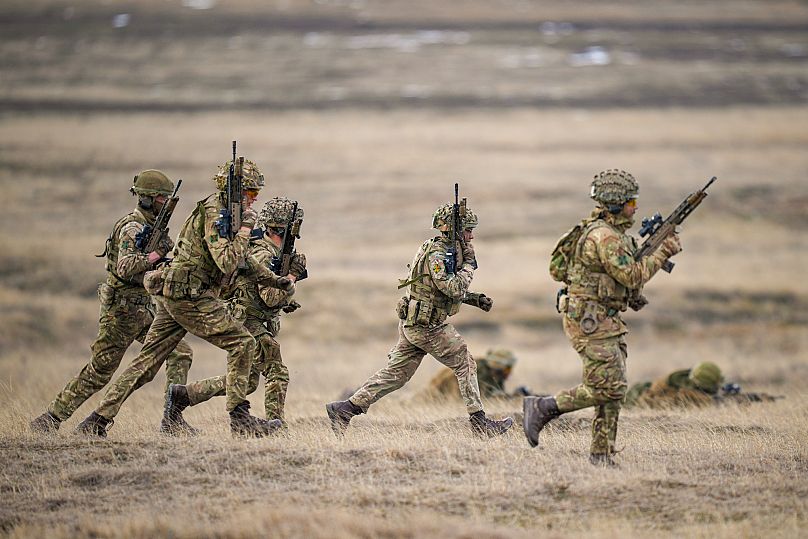 Servicemen run during the Steadfast Dart 2025 exercise at a training range in Smardan in eastern Romania, 19 February, 2025