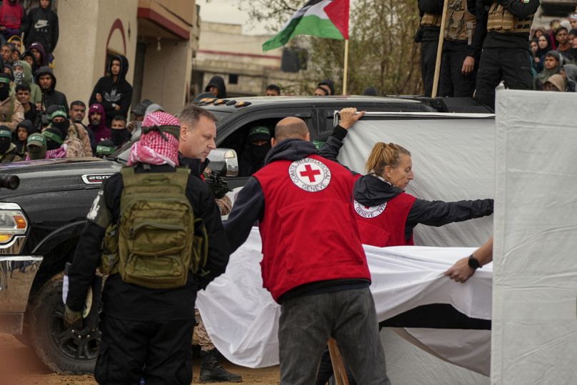 Hamas-Kämpfer übergeben dem Roten Kreuz am Donnerstag, 20. Februar 2025, in Khan Younis im südlichen Gazastreifen die Lichen.