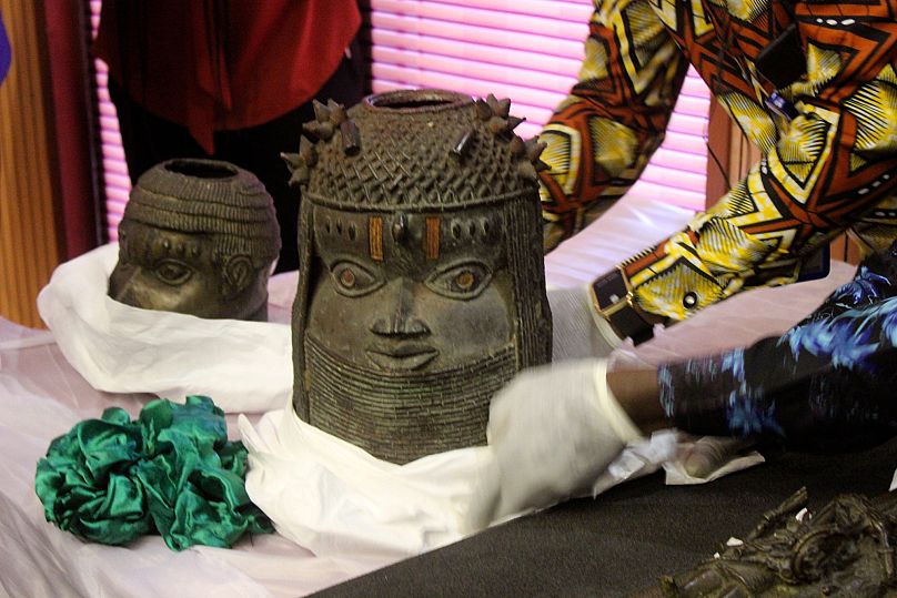 Benin bronzes looted in the past and returned to Nigeria are examined during a handing over ceremony in Abuja, Nigeria, Tuesday, Dec. 20, 2022.