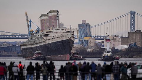 The SS United States is towed down the Delaware River between Pennsylvania and New Jersey, from Philadelphia.