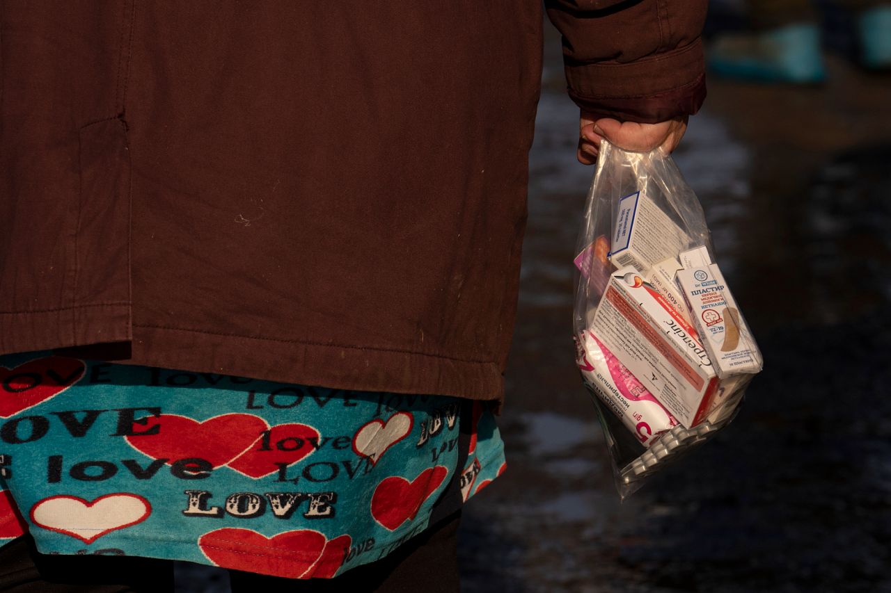 Une femme tient un sac de l'aide humanitaire (des médicaments, des produits alimentaires, des couvertures) dans le village de Blahodativka, en Ukraine, le 22 février 2023.