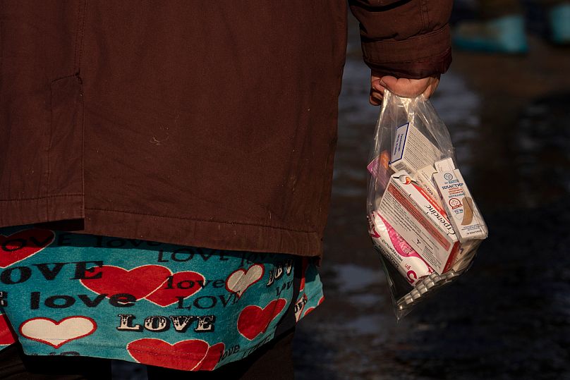 Μια γυναίκα κρατά μια τσάντα με φάρμακα που έλαβε μαζί με τρόφιμα και κουβέρτες ως ανθρωπιστική βοήθεια στο χωριό Blahodativka της Ουκρανίας, 22 Φεβρουαρίου 2023.