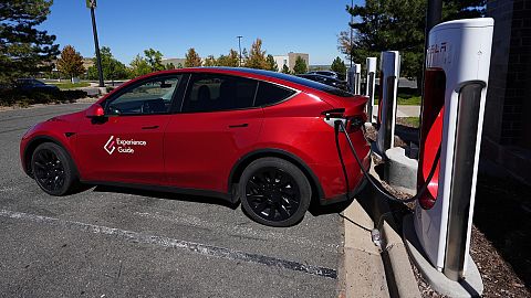  A Tesla Model 3 charges at a Tesla supercharging station in a parking lot in Lakewood, Colorado.