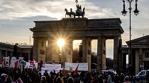 The sun sets behind the Brandenburg Gate in Berlin, Germany, Saturday, Feb. 22, 2025, one day ahead of the German election