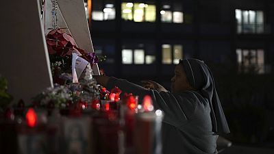 A nun adjusts candles in front of the Agostino Gemelli Polyclinic, in Rome, Saturday, Feb. 22, 2025, where the Pontiff has been hospitalized since Friday, Feb. 14