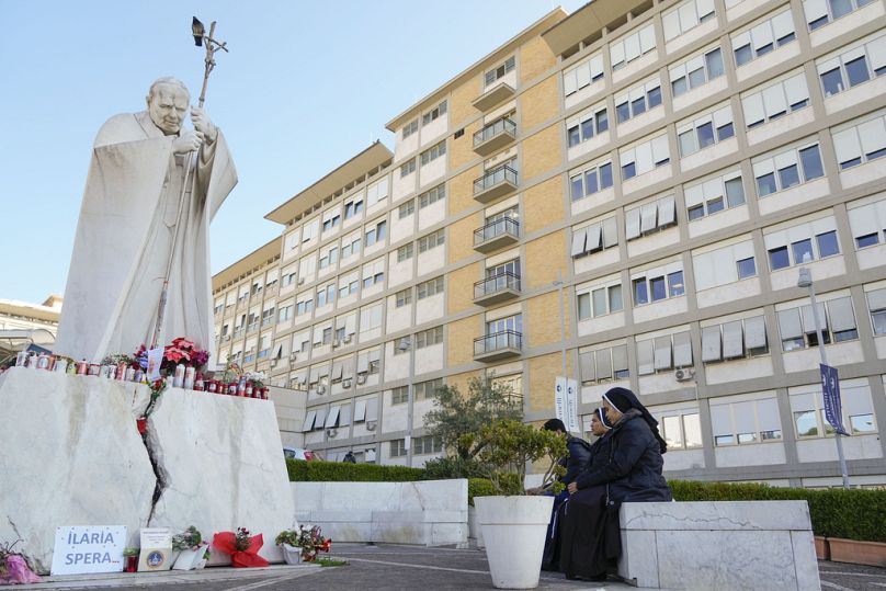 Монахини молятся перед статуей покойного папы Иоанна Павла II возле больницы Агостино Джемелли, где Франциск борется с пневмонией, в Риме, суббота, 22 февраля 2025 г.