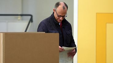 Friedrich Merz, leader of the Christian Democratic Union (CDU), walks to a polling booth with his ballot paper at a polling station in Arnsberg-Niedereimer, 23 February 2025