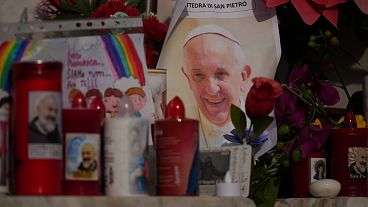 An image of Pope Francis is seen among candles in front of the Gemelli Hospital in Rome, 23 February, 2025