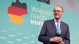 Friedrich Merz, the candidate of the mainstream conservative Christian Democratic Union party, smiles while addressing supporters at the party headquarters in Berlin, Germany.