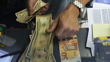 File picture of a cashier changing a 50 Euro banknote with US dollars at an exchange counter in Rome