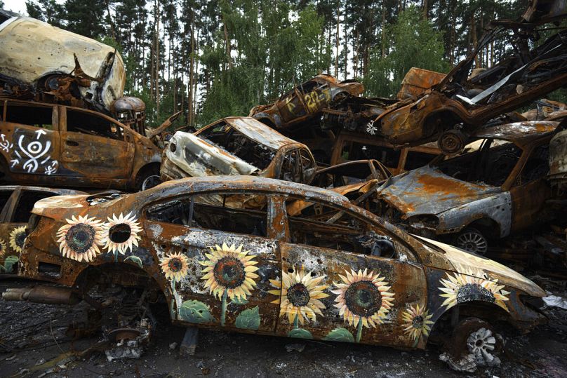 Zniszczone przez Rosjan samochody pomalowane w ramach projektu "Kwiaty nadziei", którego celem jest zebranie pieniędzy na pomoc humanitarną, okolice Irpienia 2022