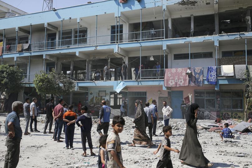 فلسطينيون يتفقدون آثار الضربة الإسرائيلية على مدرسة تديرها الأمم المتحدة، والتي أسفرت عن مقتل عشرات الأشخاص في مخيم النصيرات للاجئين بقطاع غزة، في 6 يونيو 2024.
