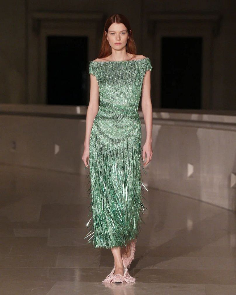 A model dazzles on the ERDEM runway, wearing a shimmering sequined dress at London Fashion Week.