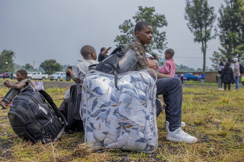 Osoby, które przekroczyły granicę Demokratycznej Republiki Konga, czekają na pomoc w Gisenyi, Rwanda.