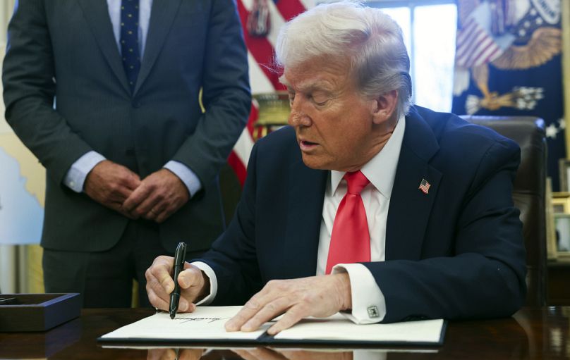 El presidente Donald Trump firma una orden ejecutiva en el Despacho Oval de la Casa Blanca en Washington, el martes 25 de febrero de 2025. 