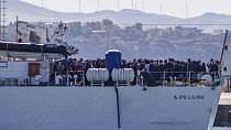 FILE - Migrants arrive in Porto Empedocle, Sicily, aboard two military ships after being transferred from the island of Lampedusa. July 27, 2020. 